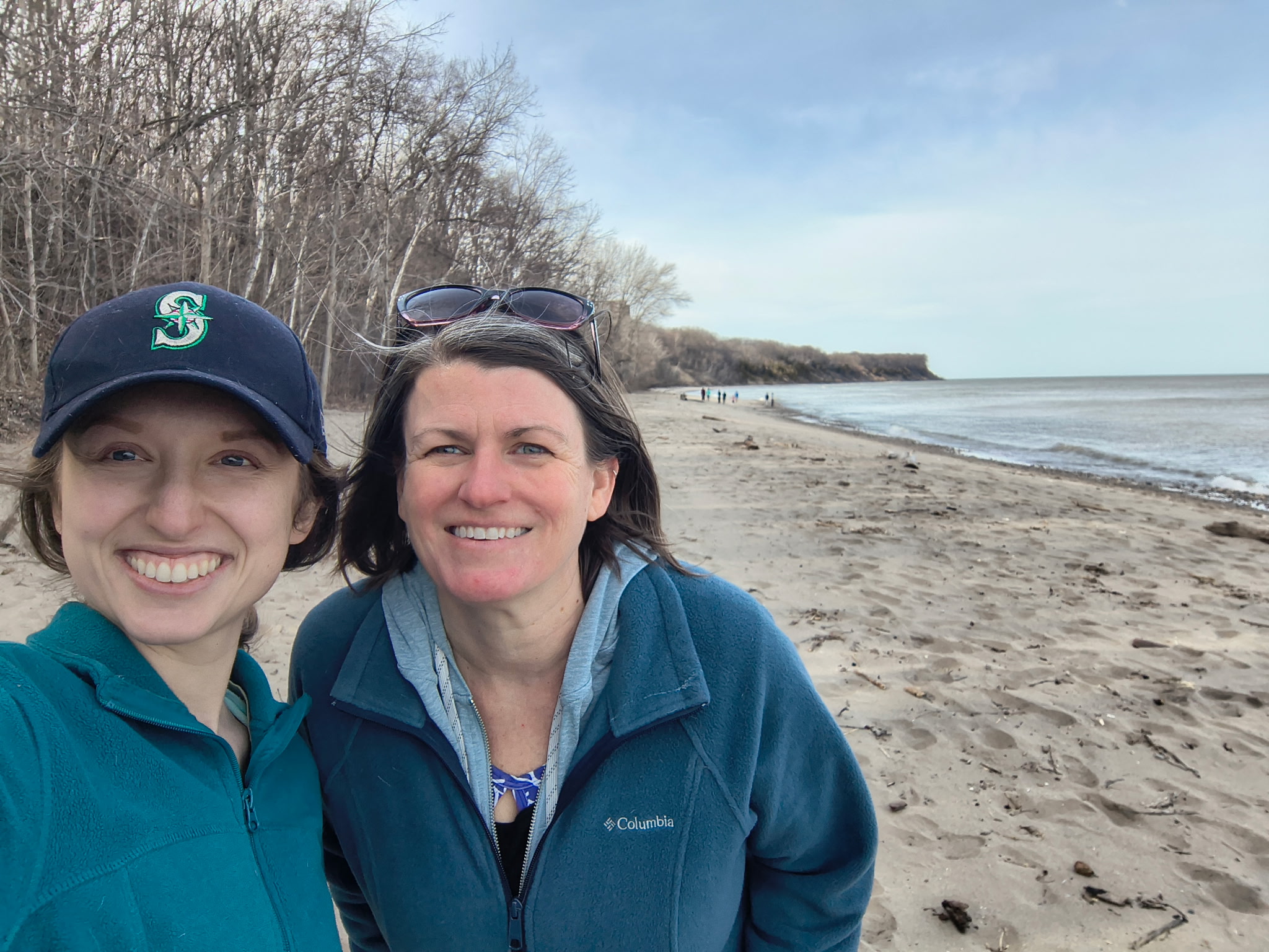 New coastal resilience specialist Carrie Malone smiles alongside Sea Grant's Deidre Peroff on a Lake Michigan beach.