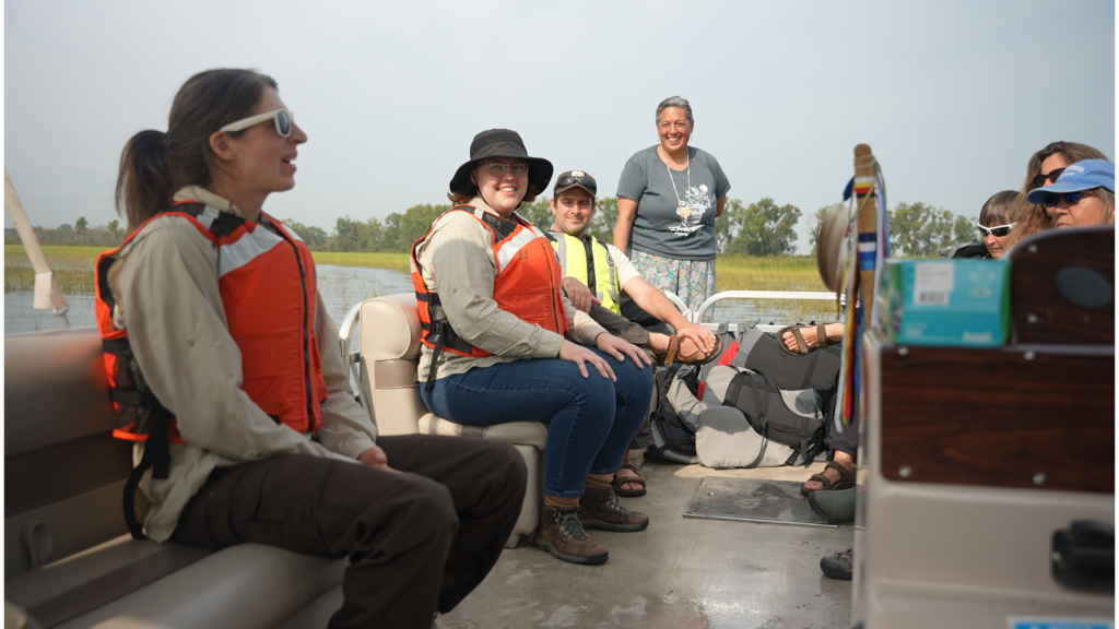 Project teams members smile during a discussion on the boat.