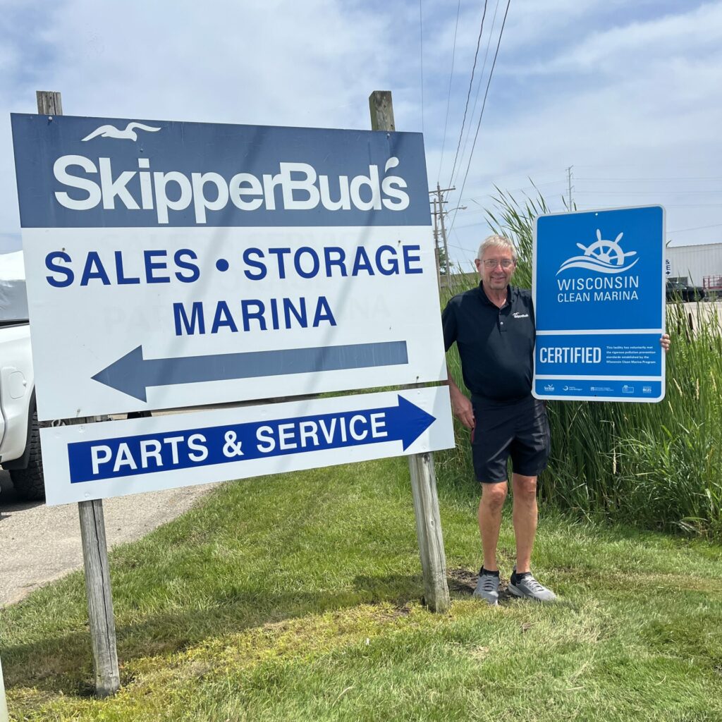 A person holding their new certified Wisconsin Clean Marina sign.