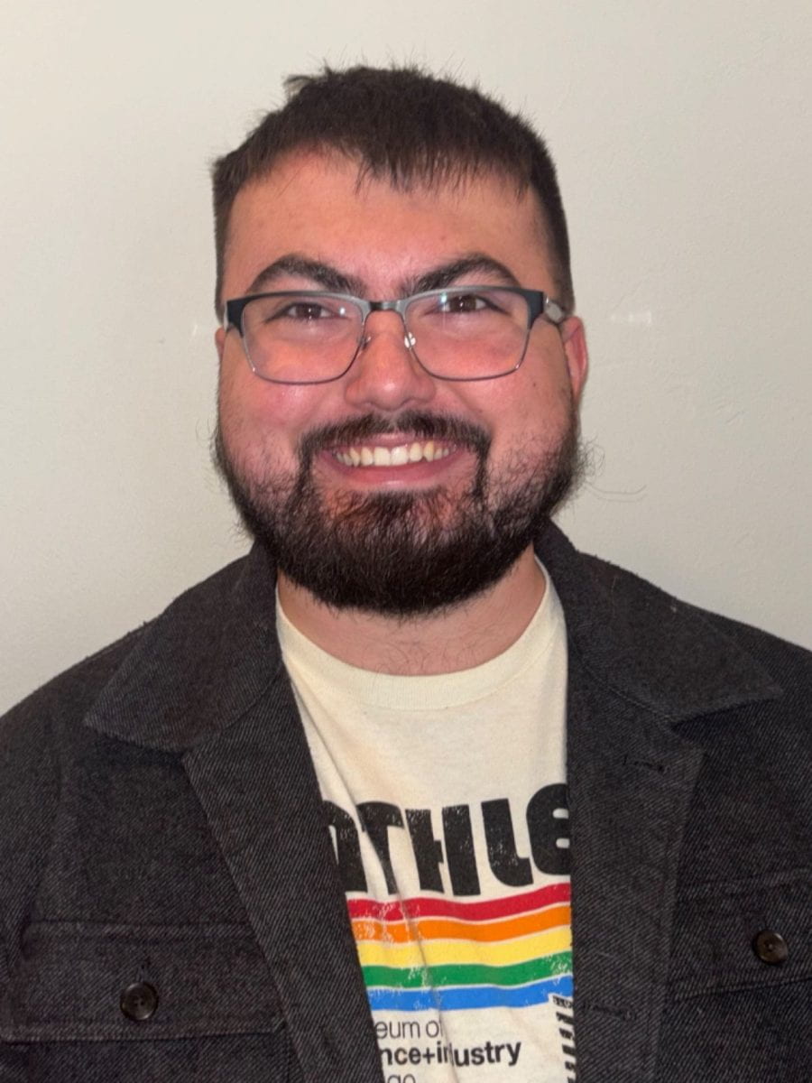 Headshot of a man with glasses and a dark beard