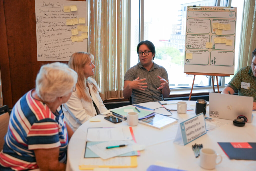 Three workshop participants discuss water quality around a round table.