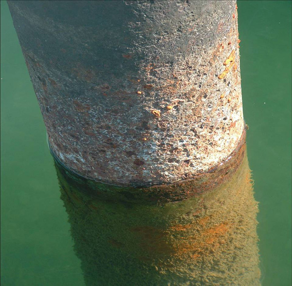 Cylindrical steel piling covered in rust