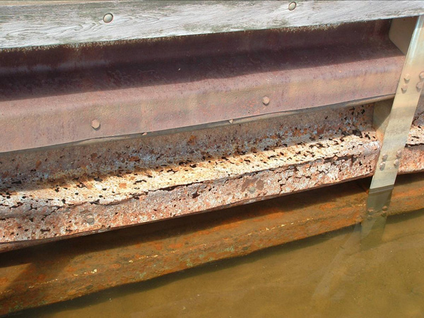 Rusty steel sitting above a murky waterline