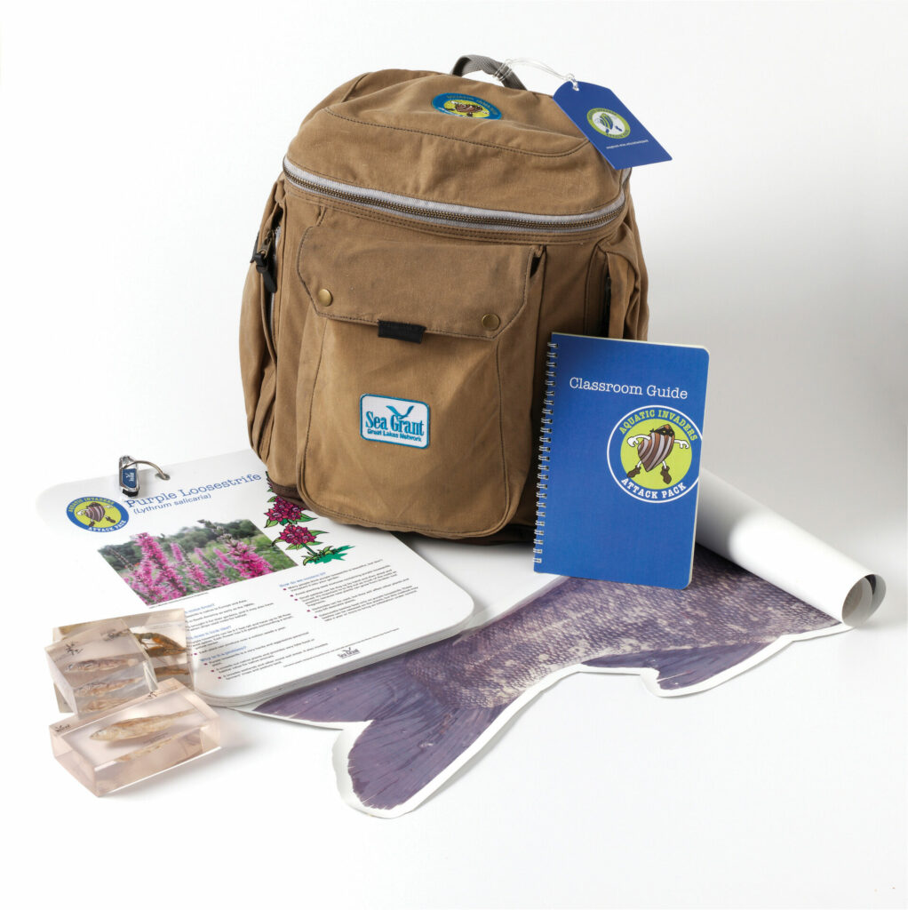 Canvas backpack with assorted aquatic invasive species outreach materials spread around it