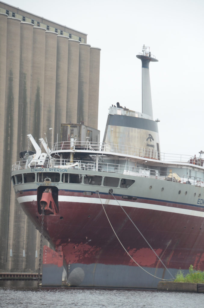A large cargo ship tied and docked to a mooring.